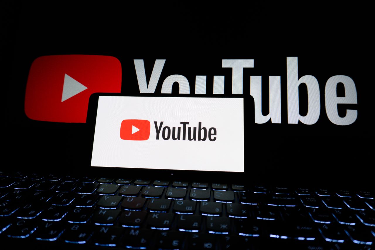 project-02-b Close-up of YouTube logo displayed on a laptop screen in a dark environment.